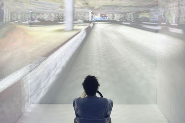 Student mit Lenkrad auf virtueller Rennstrecke